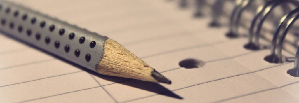 Sharp pencil laying on a notepad