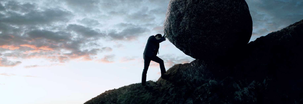 Man psuhing a large boulder up a mountain to show risk manager role