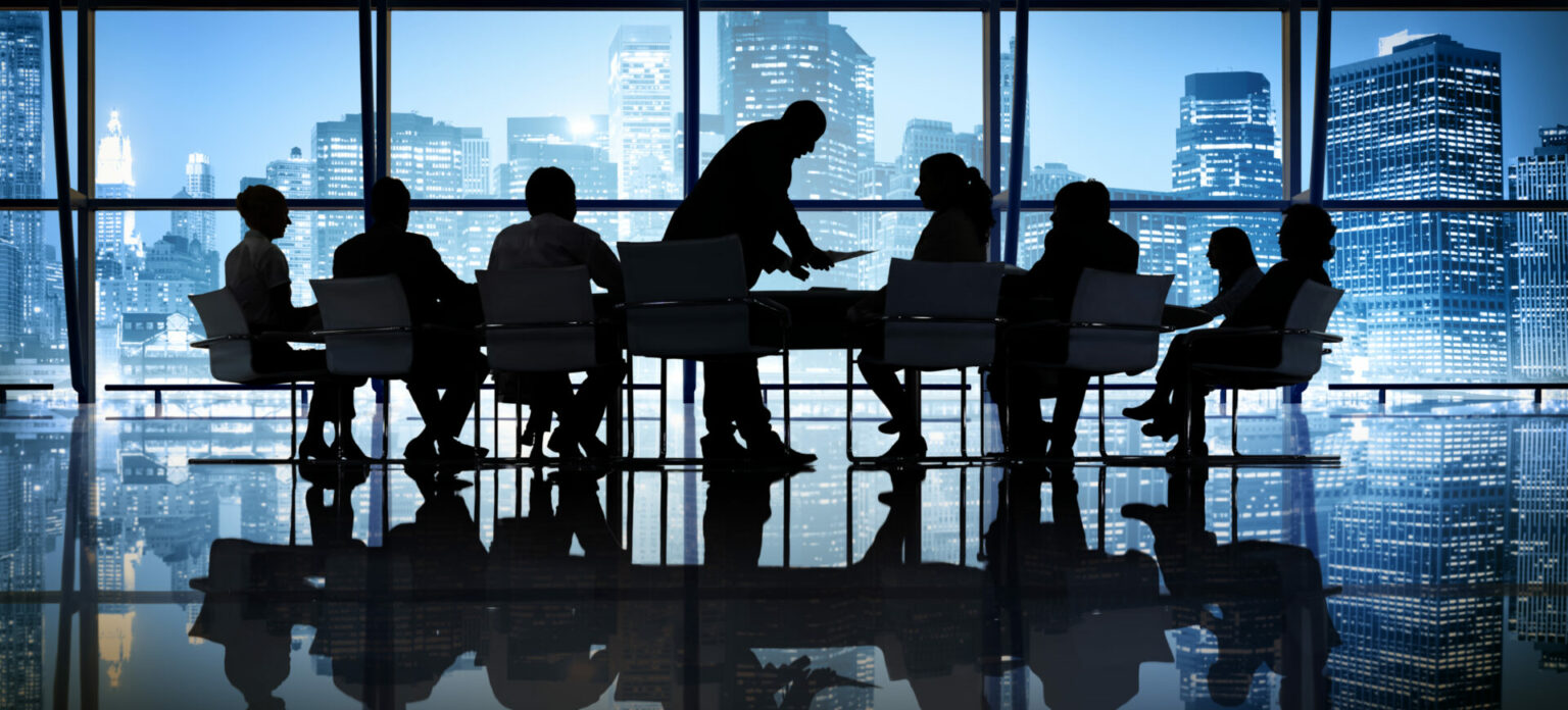 Silhouette of business people in a meeting in front of a city scape