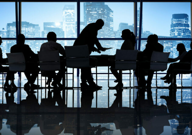Silhouette of business people in a meeting in front of a city scape